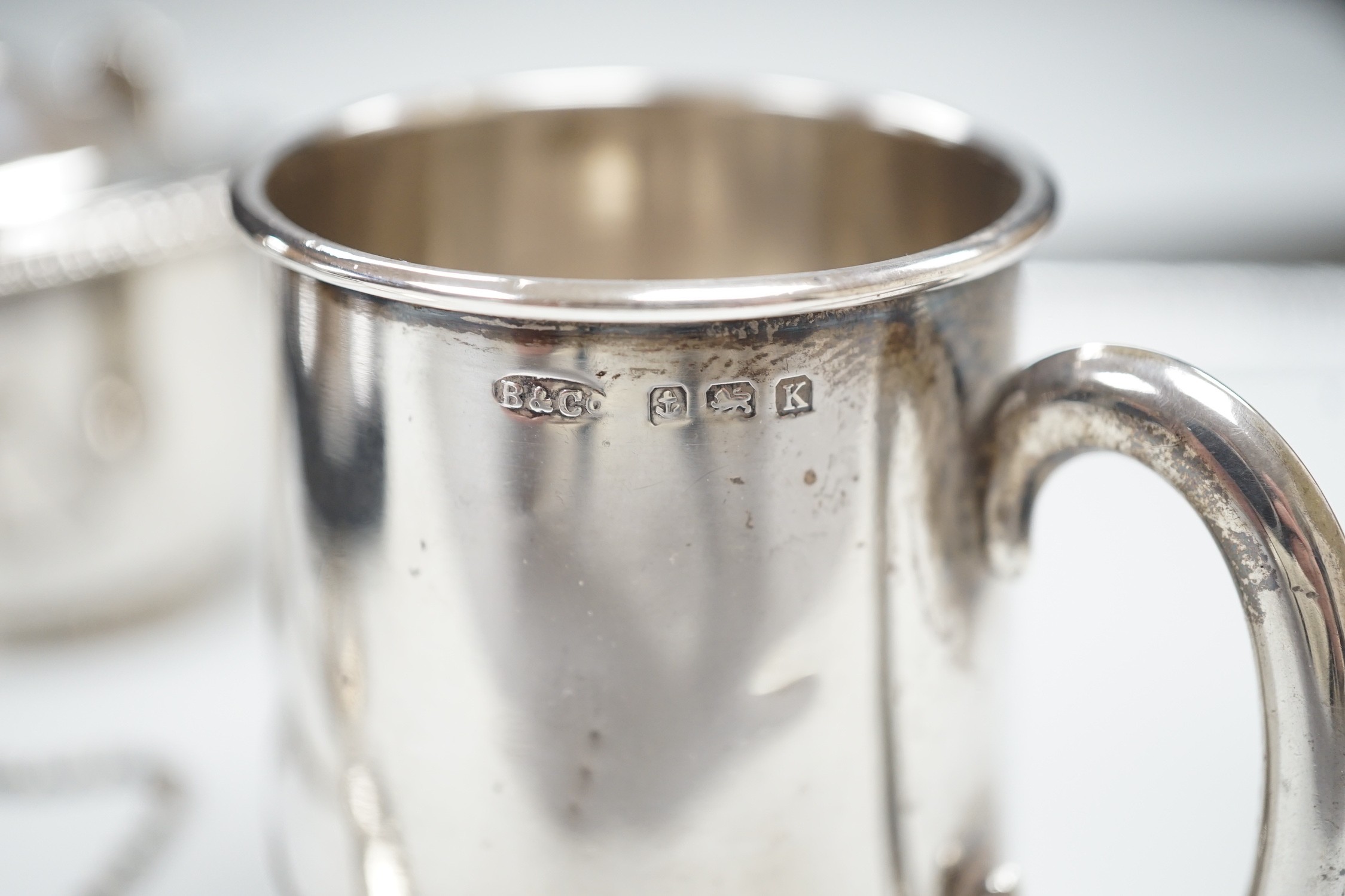 A small 1930's silver christening mug, two 19th century silver decanters labels 'Claret' and 'Marsala' and a white metal mounted polished wood shield 'Roborough School, Eastbourne Chess' and a Victorian silver oval musta